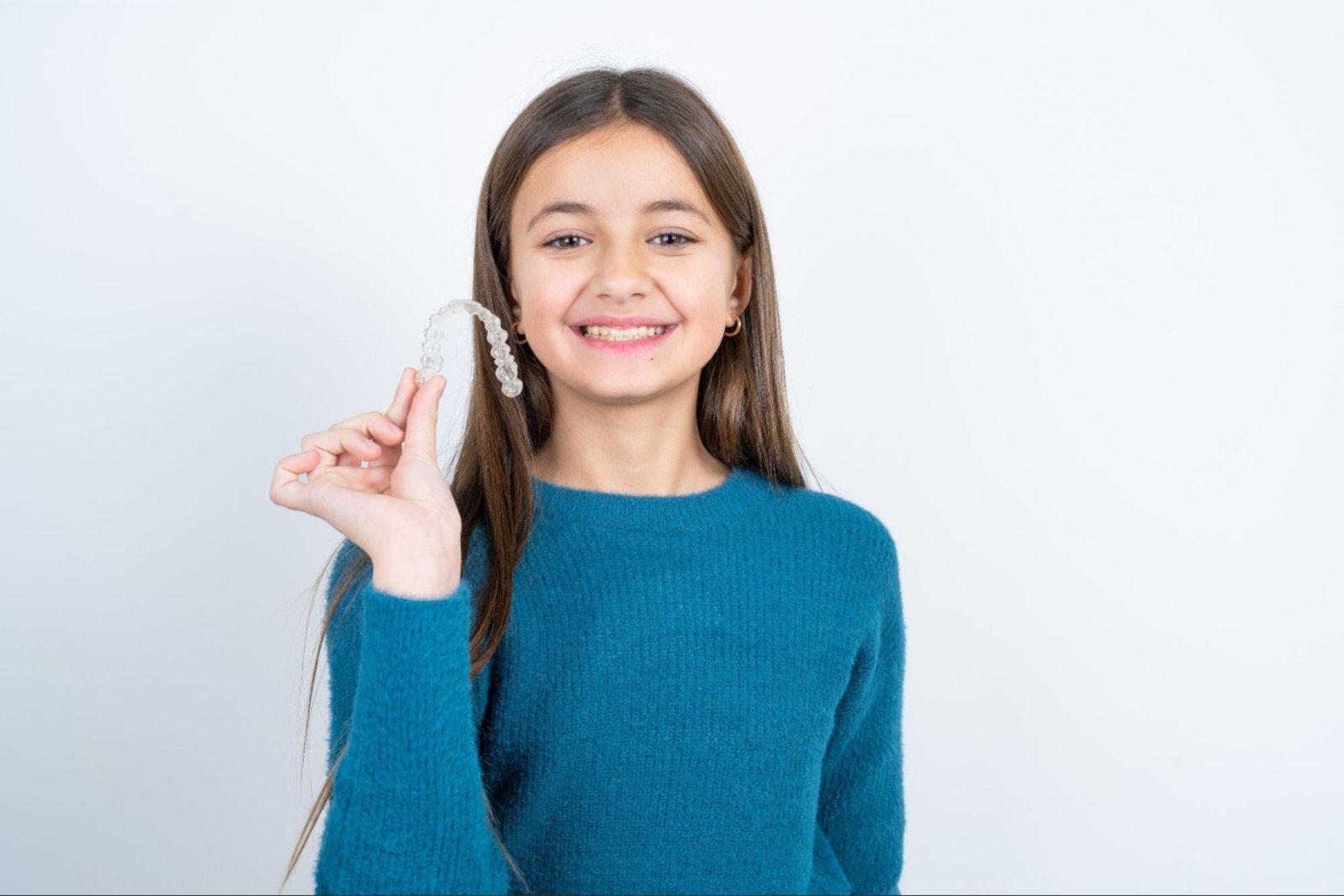 Child holding a clear aligner