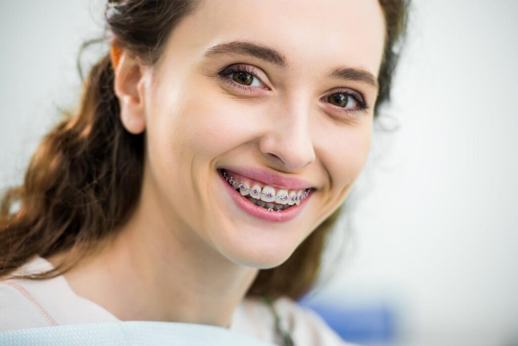 Adult patient smiling with metal braces