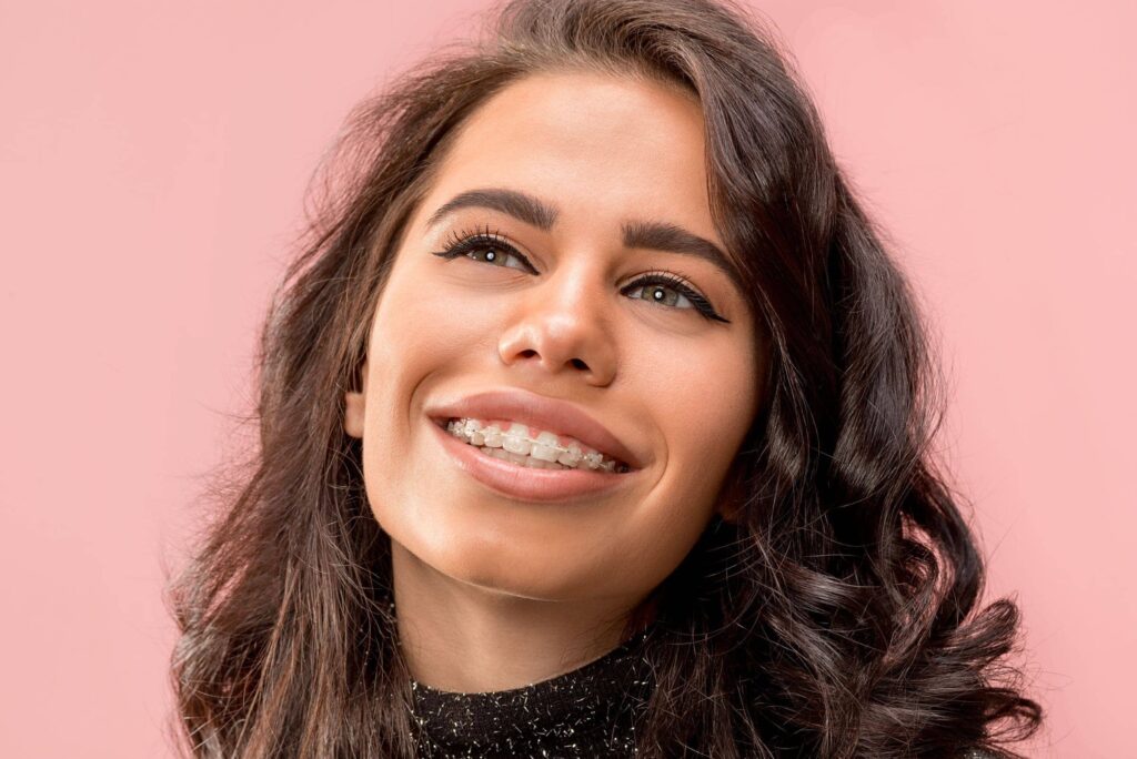 Young woman with braces smiling and looking up